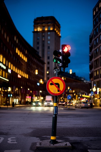 Photo close-up of signboard and signal on road at night