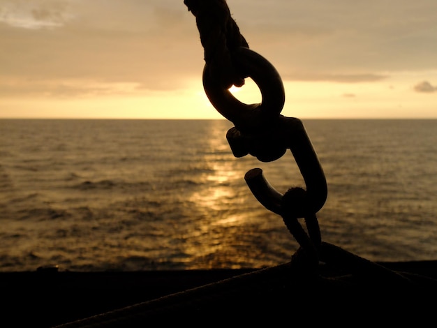 Foto close-up della catena di silhouette contro il mare durante il tramonto