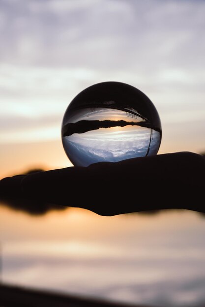 Foto close-up di una sfera di cristallo a silhouette contro il cielo durante il tramonto