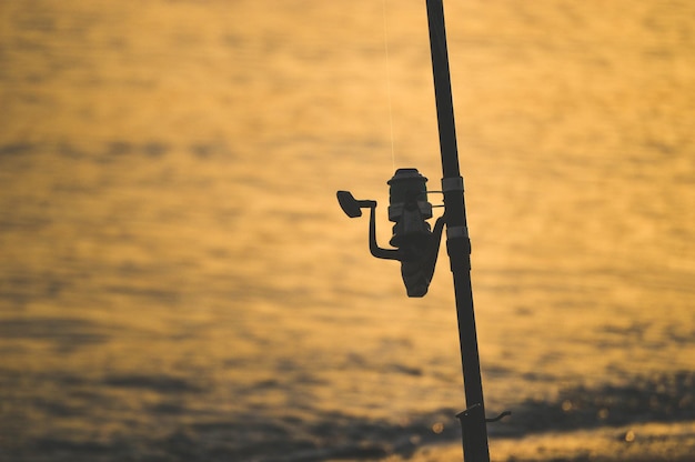 Foto close-up della silhouette della canna da pesca sul palo