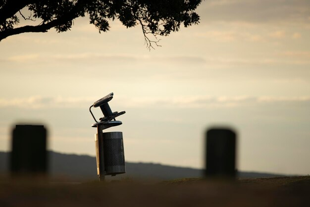 Photo close-up of silhouette metal on field against sky