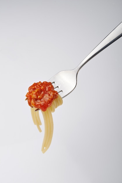 Photo close up of a silver fork with bolognese and spaghetti