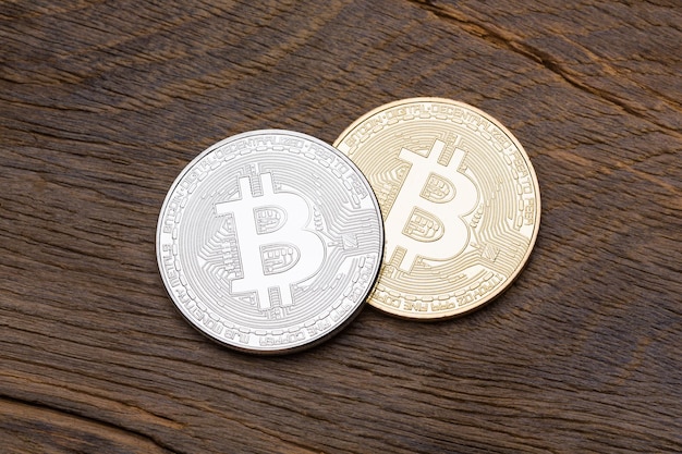 Close up of silver and golden bitcoins on wooden background macro shot High resolution photo