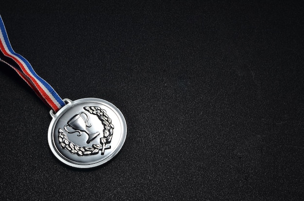 Close-up of silver medal on black table