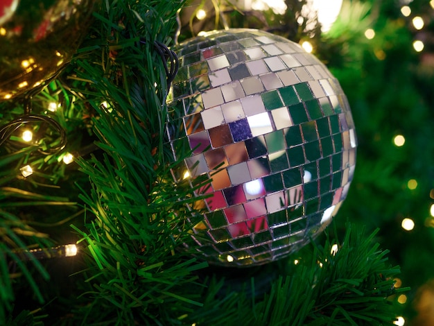 Close up silver shiny ball on Christmas tree and fairy lights