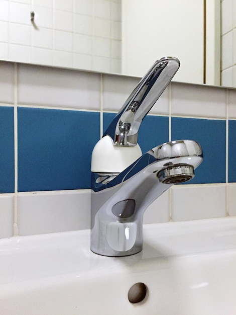 Photo close-up of sink faucet in bathroom