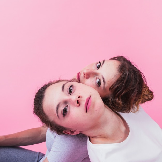 Photo close-up of sister leaning head on each other's shoulder