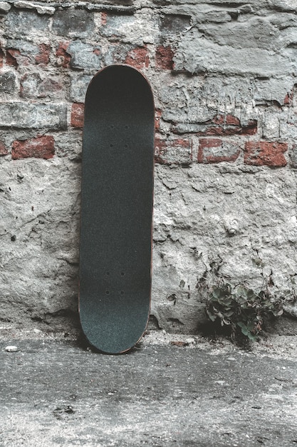 Photo close-up of skateboard by weathered wall