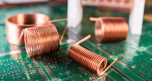 Close-up of skeins of twisted copper wire are standing on a green microcircuit