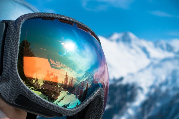 Close-up of ski goggles by snow covered mountains