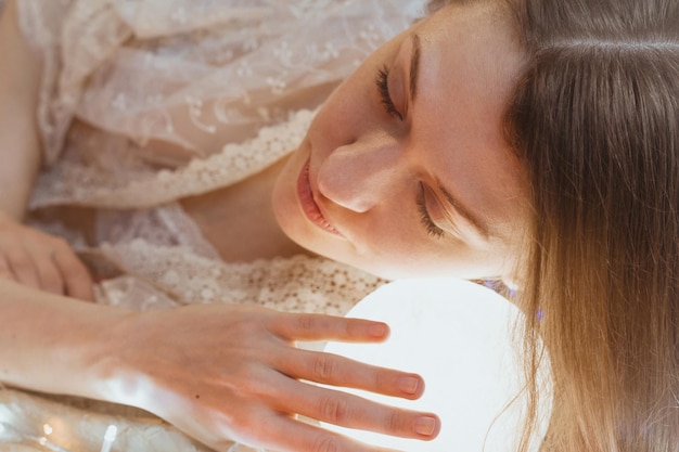 Close up sleeping woman with head on glowing ball light portrait picture