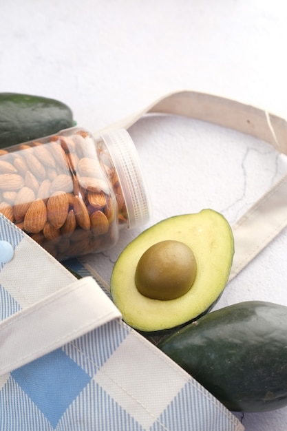 Close up of slice of avocado and almond nut on chopping board