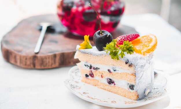 プレートのスライス誕生日フルーツケーキを閉じる