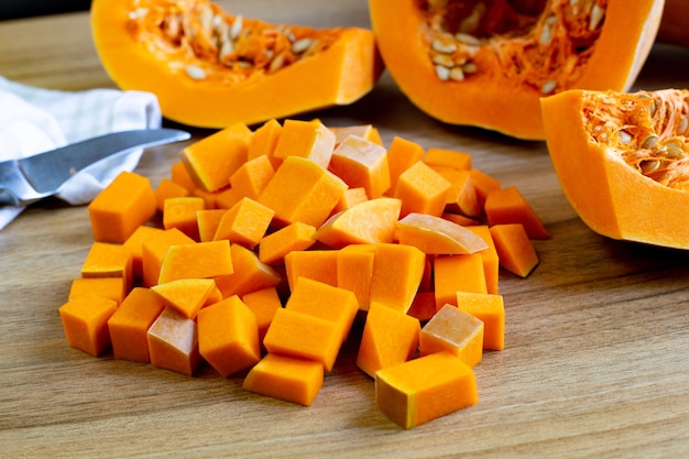 Close-up of sliced ââripe raw pumpkin on a wooden table