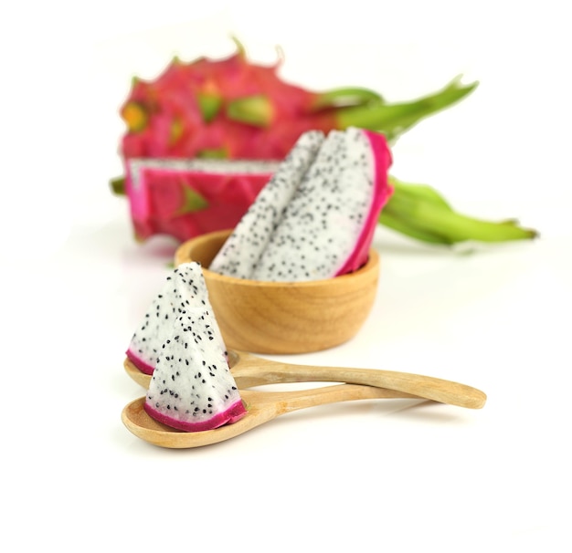 Close up sliced dragon fruits on spoon on white