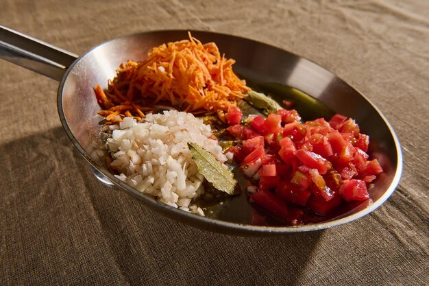 Close-up of sliced fresh vegetables fried in a steel pan