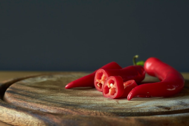 Close-up of sliced red hot chili peppers on wooden cutting board