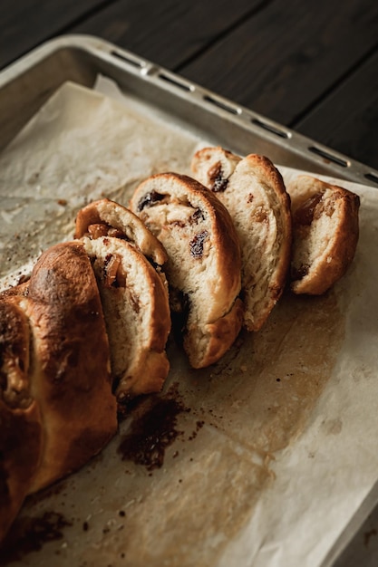 A close-up of sliced sweet cottage cheese braided bread with raisins and jam.