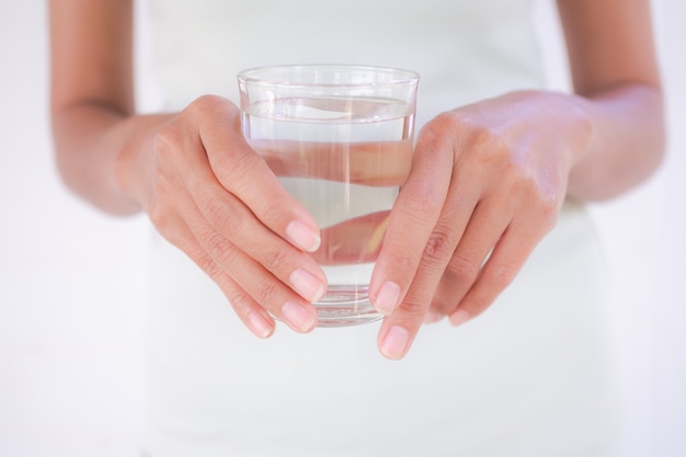 Close up slim hand woman holding water glass. lady authentic skintan and fit shapely. for Lose weight by drin water and for good health.