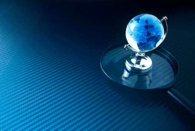 close-up of small globe on magnifying glass