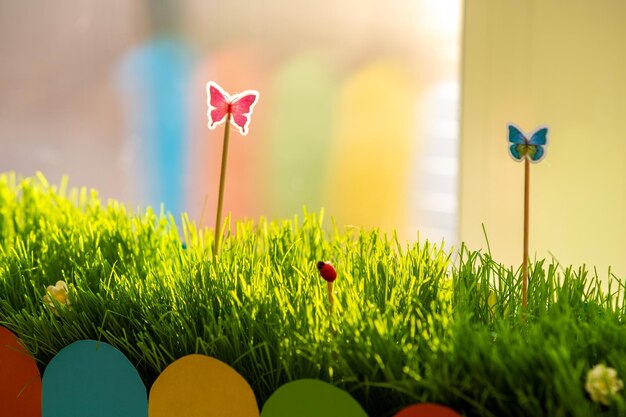 Close up of small green grass with special cute toys small butterflies. Concept of beautiful plants with decoration.