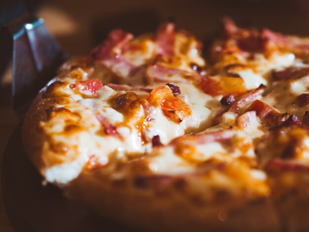Photo close up of small size of ham and cheese pizza.