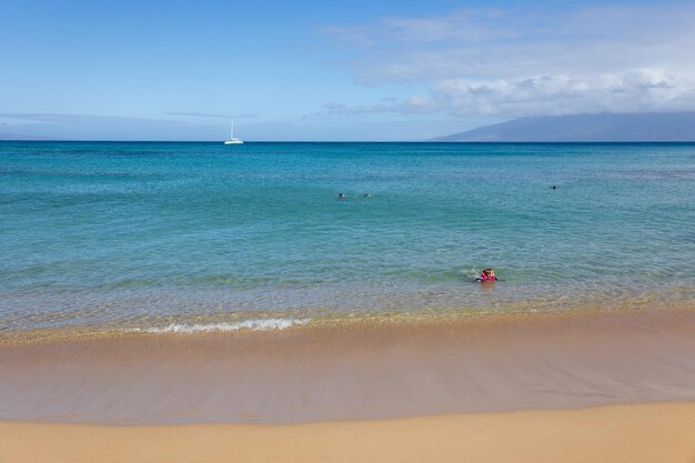 熱帯のビーチの砂の上の小さな波のクローズアップ海の水の背景