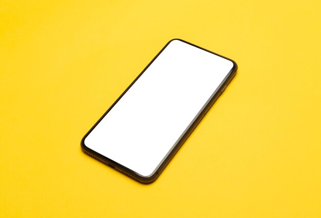 Close-up of smart phone against yellow background