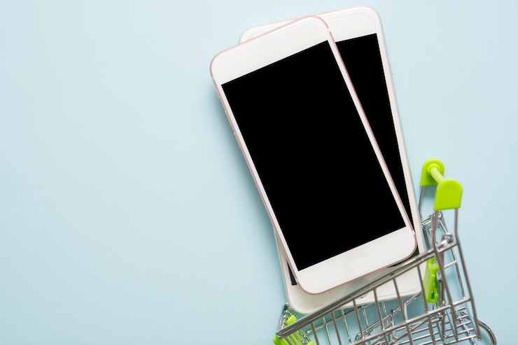 Photo close-up of smart phone with shopping cart on blue background