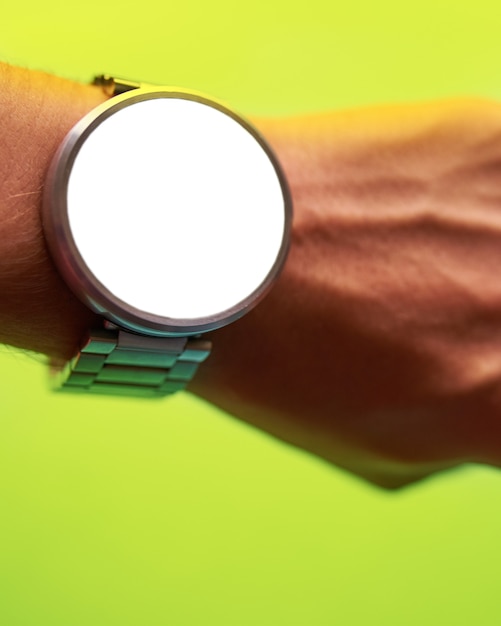 Close up smart watch on hand on bright lime green background with isolated, blank screen f