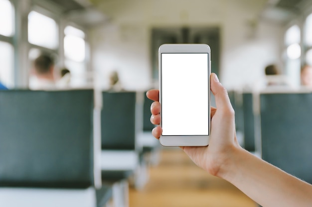 Close up of smartphone in the hands of woman Against the background of train carriage