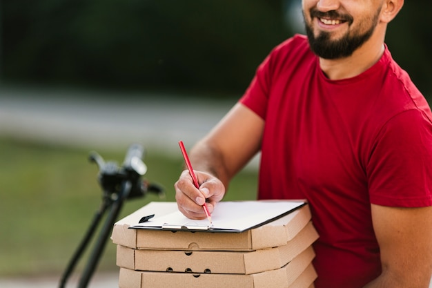 Photo close-up smiley delivery guy with clipboard