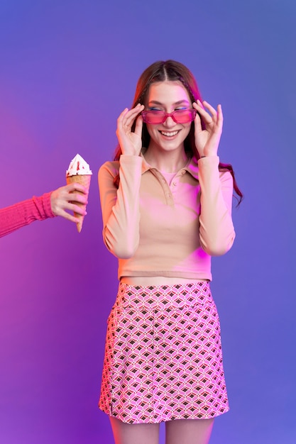 Foto chiuda sulla ragazza sorridente che esamina il gelato