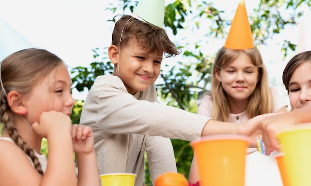 写真 カップで祝う笑顔の子供たちをクローズアップ