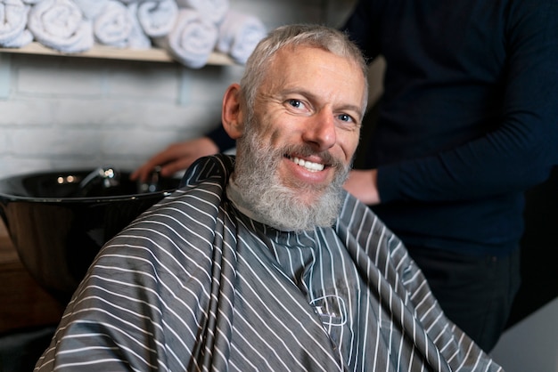 Close up uomo sorridente al negozio di parrucchiere Foto Premium