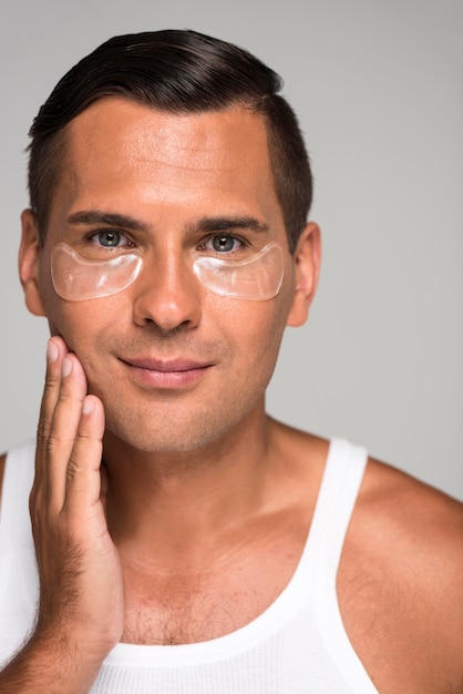 Photo close-up smiley man with under eye patches