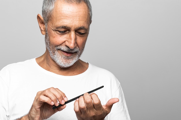 Close-up smiley senior man filing his nails