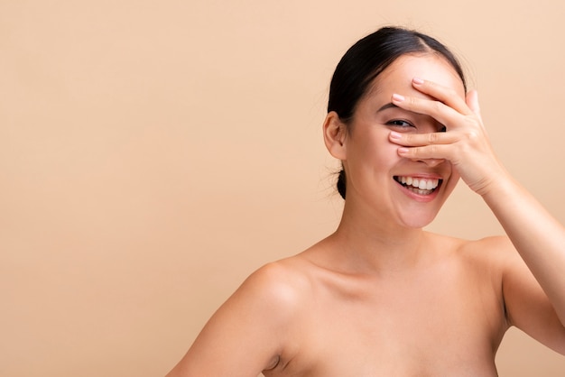 Close-up smiley woman covering her eyes with copy-space