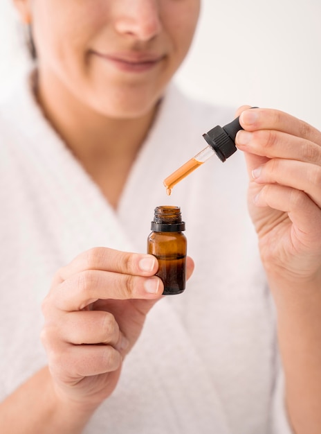 Close-up smiley woman holding serum