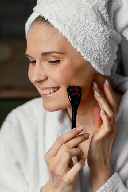 Photo close up smiley woman using facial tool