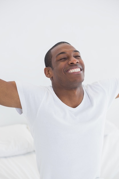 Close up of smiling Afro man stretching his arms out