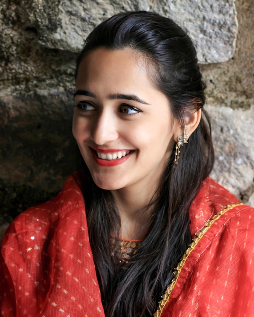 Photo close-up of smiling beautiful woman against wall