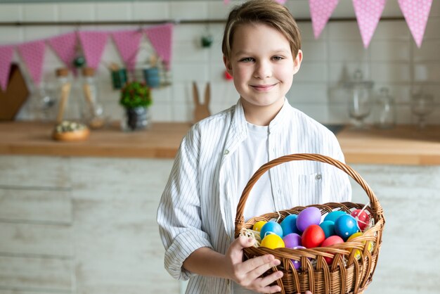 Close up of smiling boy with basket of Easter eggs.