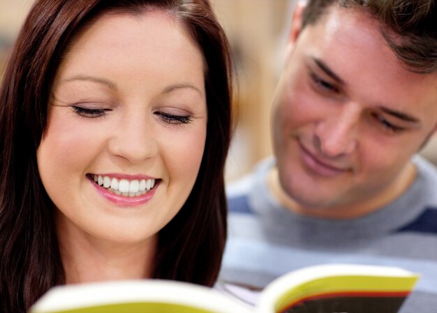 書籍を読む学生の笑顔のカップルのクローズアップ