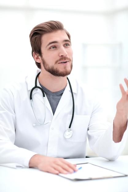 Close up of smiling doctor sitting behind a Desk