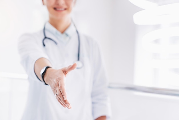 Close up of smiling female doctor giving her hand for handshake