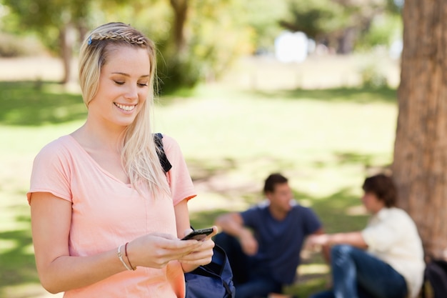 Close-up of a smiling girl using a smartphone