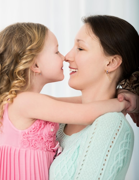 Photo close-up of smiling mother and daughter at home