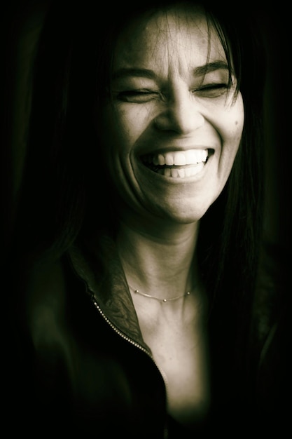 Foto close-up di una donna sorridente su uno sfondo nero