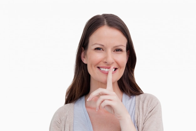 Close up of smiling woman asking for silence